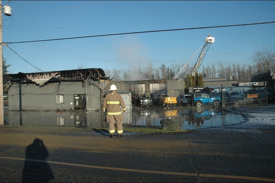 A ladder truck was used to extinguish the last of the flames after a fire destroyed an auto-body shop on Boys Road early Tuesday morning. (Robert Barron/Citizen) 