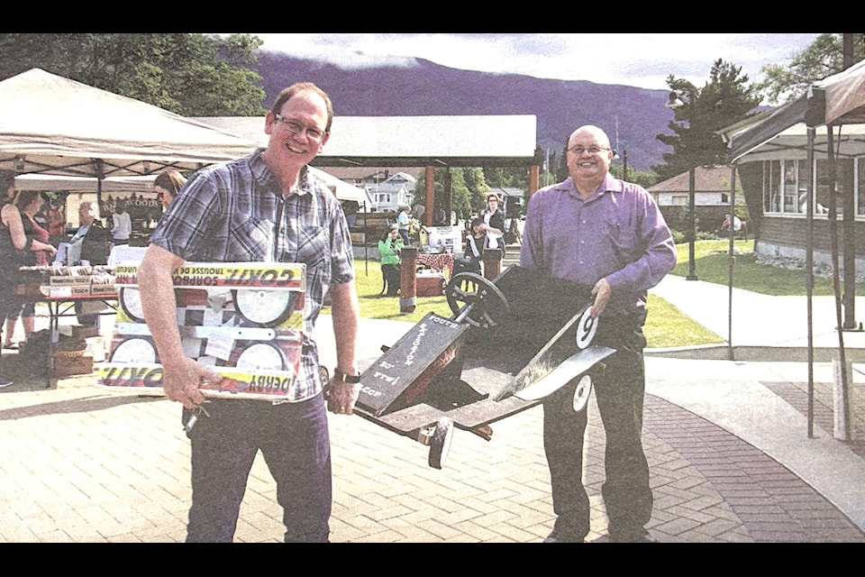 "At the premier of the Lake Cowichan Downtown Farmers Market last Saturday (May 16), Pastor Terry Hale and David Craft show off their soapbox cars and the kits they had for sale to enter this year's Lake Days Soapbox Derby. The popular race will be held only one day this year, on Sunday, June 7.