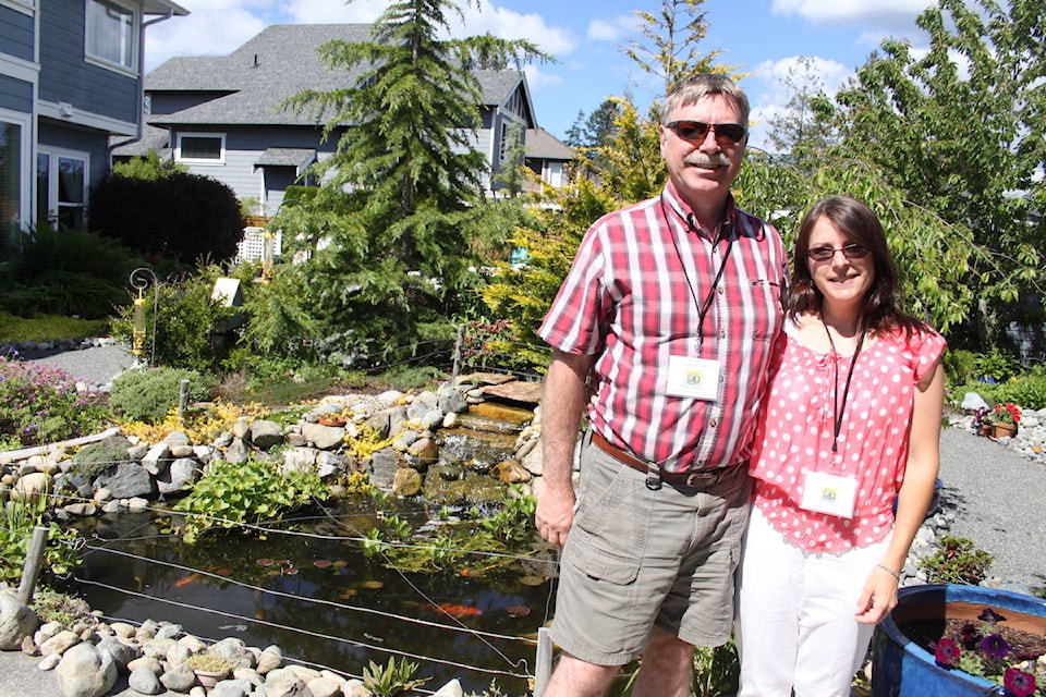 Garden owners Gail and Roger Andersen stand in front of their pond at their home in Mill Bay during Cowichan Family Life’s 23rd Annual Cowichan Valley Garden Tour on Sunday, May 4. They’re now replaced 90 per cent of their grass with garden beds and paths. They also have some epic-sized koi! (Andrea Rondeau/Citizen)