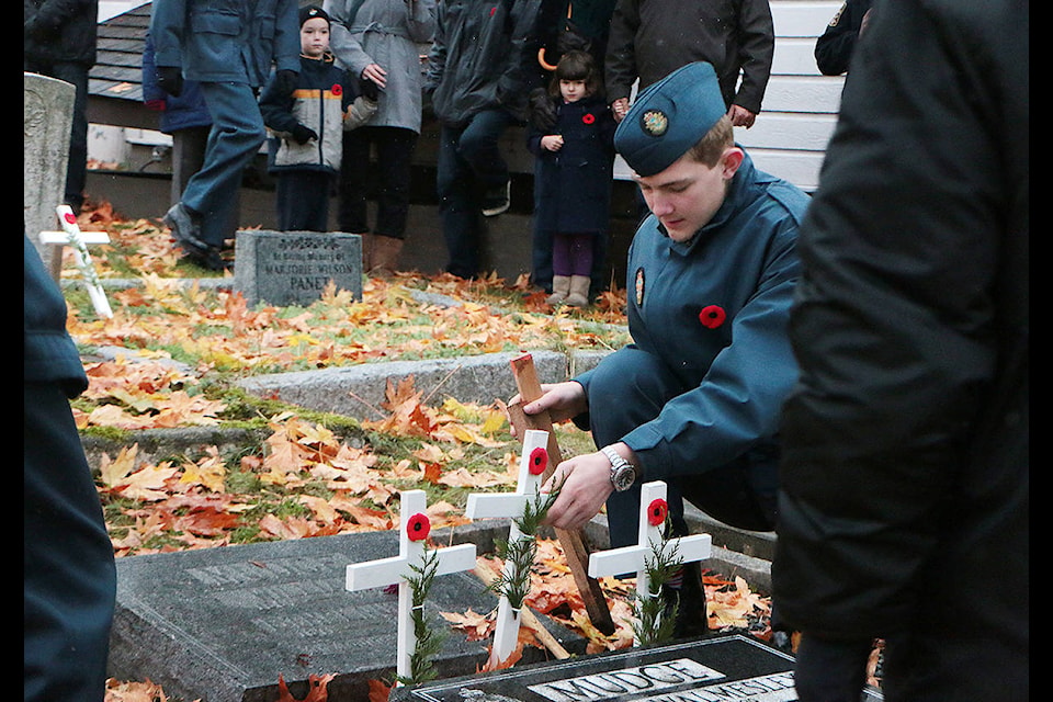 A cadet hammers in a white cross to honour a veteran at St. Francis Xavier Church in Mill Bay during cross ceremonies. (Kevin Rothbauer/Citizen)