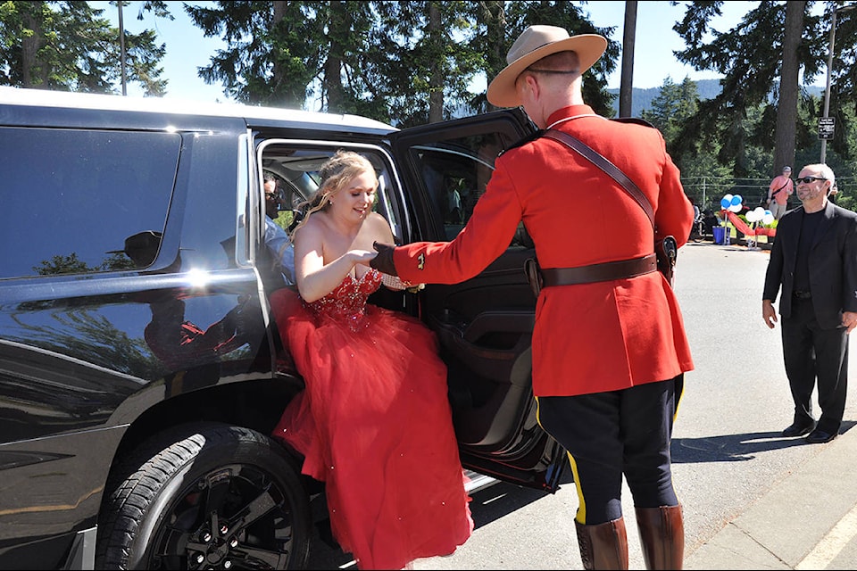 A Mountie in red serge helps a graduate upon arrival. (Warren Goulding/Citizen)
