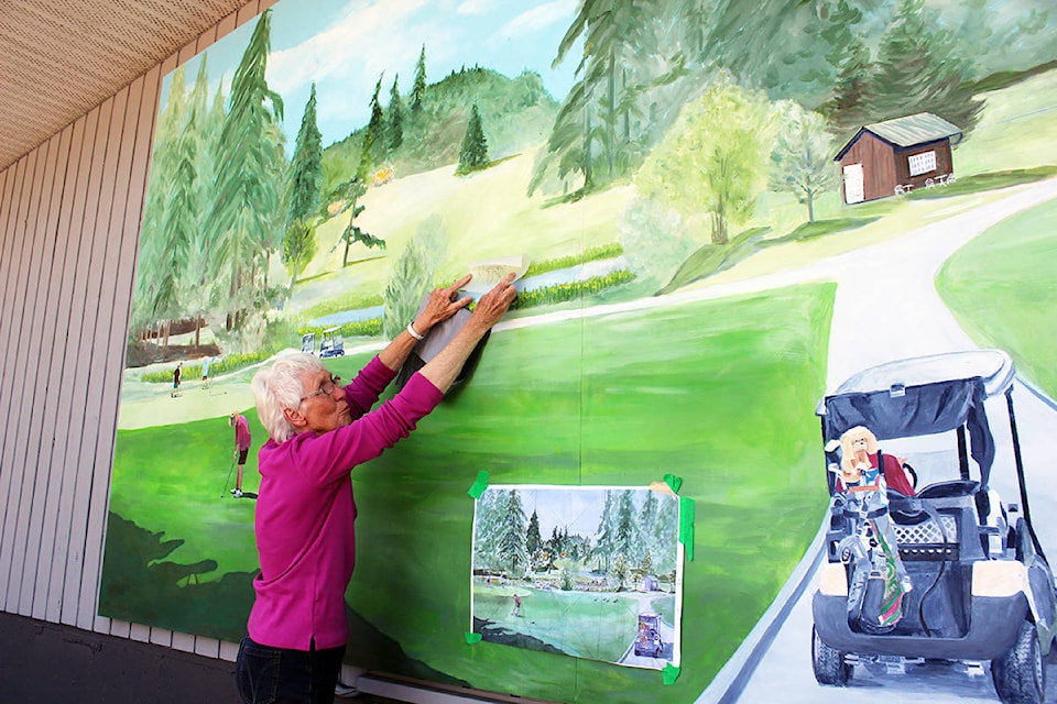 Cim MacDonald plots where some ducks in flight might be added to her mural at the Mount Brenton Golf Club. (Photo by Don Bodger)