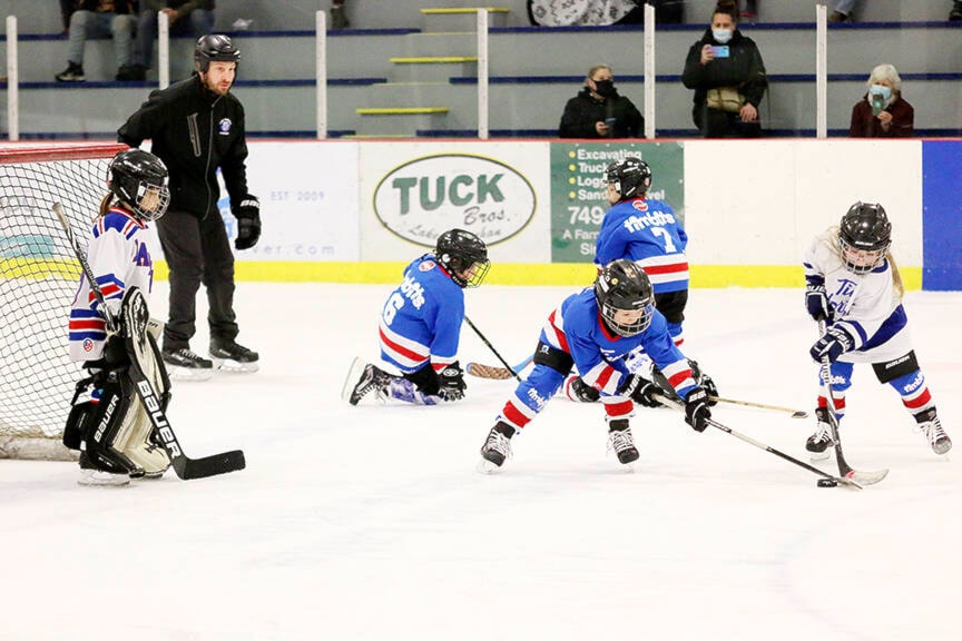 Above right: U7 Lakers players Mason Cummings and Summer Merrick battle for the puck. (Kevin Rothbauer/Gazette)