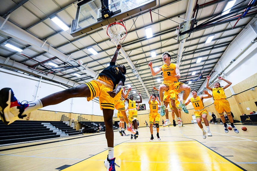 Shawnigan Lake School’s Jimi Ademola dunks during warmups ahead of a game at the 2A boys North Island basketball championships. (Arden Gill/Shawnigan Lake School)