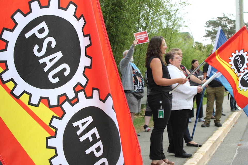 CFB Esquimalt workers and those in solidarity rally outside the naval base Wednesday. Their union leader called the federal government’s most recent wage negotiation offer insulting. (Jake Romphf/News Staff)