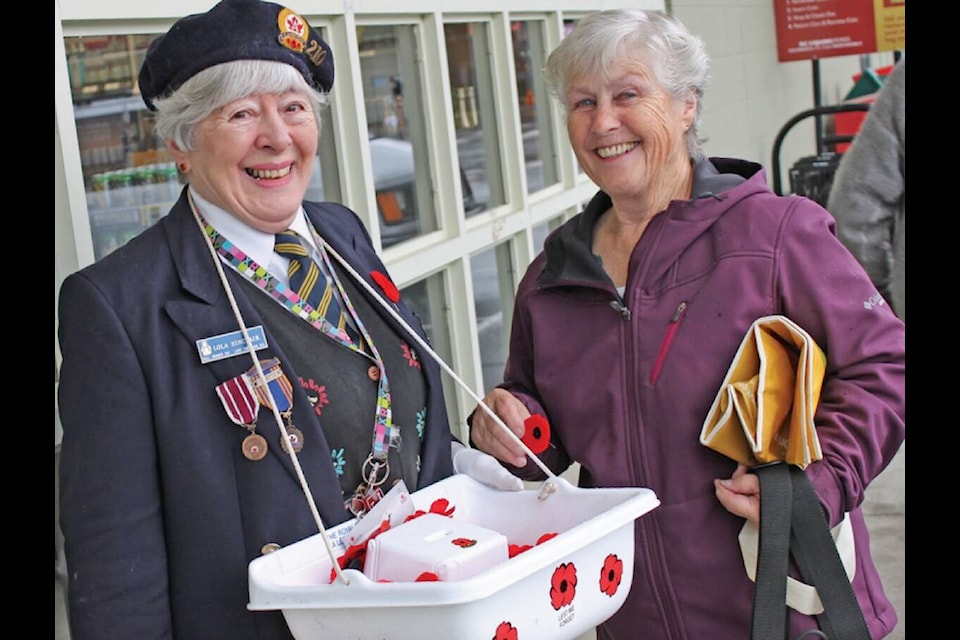 “Legion member Lola Sinclair was busy selling poppies around Lake Cowichan last week. Here she helps Lois Atchison purchase her poppy in honour of Remembrance Day. The mission of The Royal Canadian Legion is ‘to serve veterans and their dependents, to promote Remembrance, and to act in the service of Canada and its communities.’ The major source of funding for the Legion to accomplish this work is the annual Poppy Campaign, the foundation of the Remembrance Program. It is the generosity of Canadians through this program that enables the Legion to ensure that veterans and their dependents are cared for and treated with the respect they deserve. Since 1921, the Poppy has stood as a symbol of Remembrance and now every November, Poppies blossom on the lapels and collars of over half of Canada’s entire population.” (Lake Cowichan Gazette, Nov. 7, 2012)