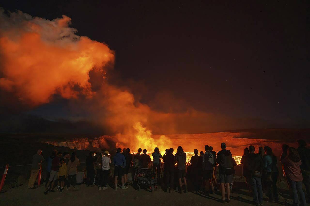 This photo provided by Janice Wei shows people watching the eruption inside the summit crater of the Kilauea volcano on the Big Island of Hawaii, Thursday, Jan. 5, 2023. Kilauea, one of the worlds most active volcanoes, is erupting again and providing a spectacle that includes bursting lava fountains and lava waves but no Big Island communities are in danger. (Janice Wei via AP)