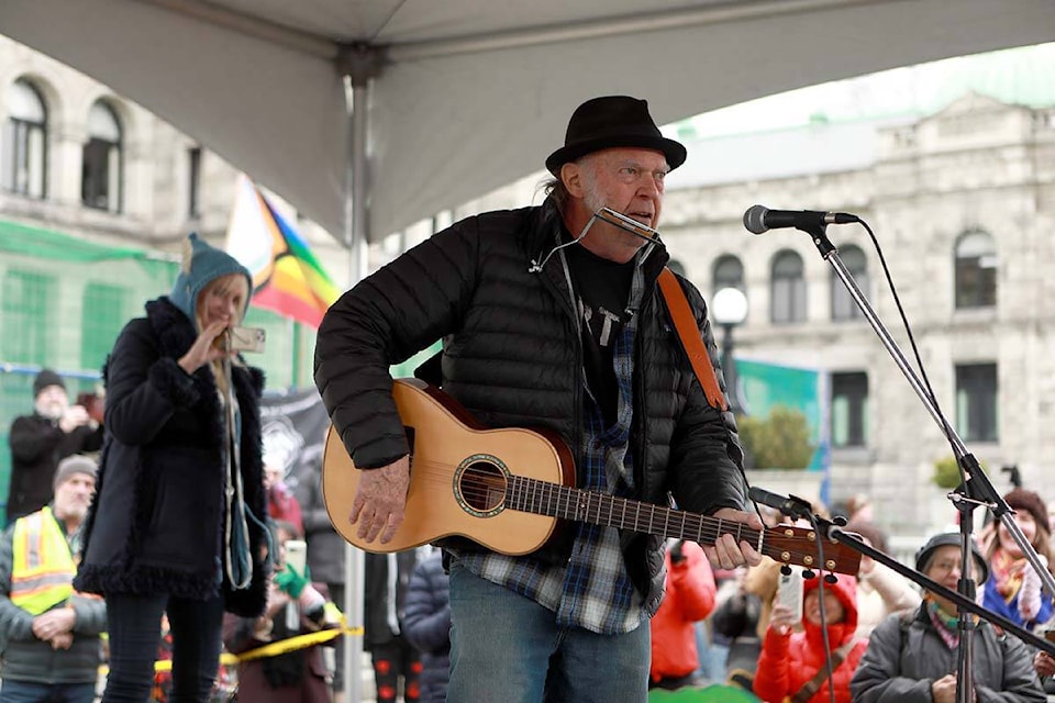 Rock legend Neil Young performs during a rally against the destruction of old growth forests on the front lawn of the legislature in Victoria, B.C., on Saturday, February 25, 2023. THE CANADIAN PRESS/Chad Hipolito