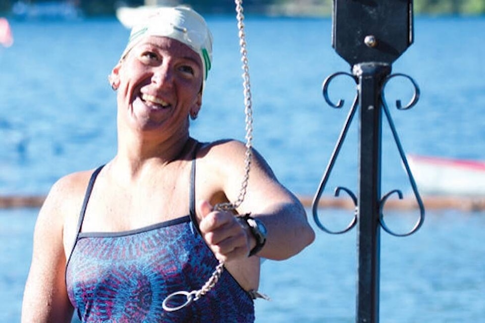 ”After nearly 12 hours in the water, 48-year-old Susan Simmons completes her 34-kilometre swim, the length of Cowichan Lake, by walking up the beach and ringing the bell. Simmons commented about the swim saying she never wants to eat another gel pak of food again. Throughout the day, food and water were carefully transferred to her by the support team.” (Lake Cowichan Gazette/July 24, 2013)