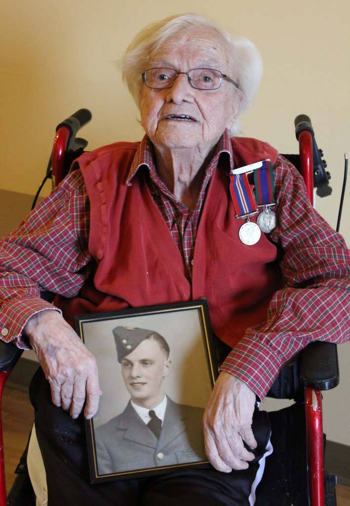 Clifford Brunt holds a photo of himself as a member of the Air Force during the Second World War. (Credit: Eric Brunt)