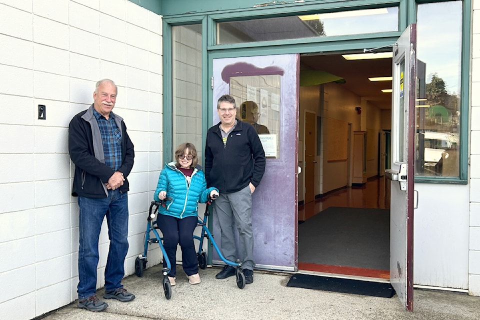 Mayor Arnold DeBoon and Principal Ken Wiens pose in front of Homelinks with Alexis Folk, who advocated for the new accessible doorway.