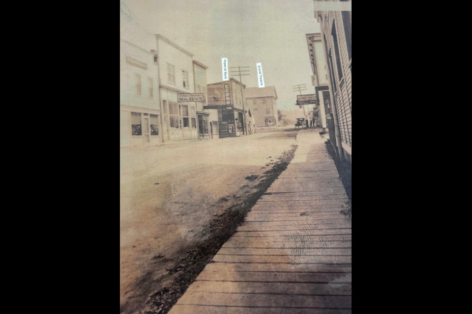 Main Street of Creston pictured in 1922. The Imperial Bank and Grand Theatre can be seen at the end of the street, complete with wooden sidewalks. 