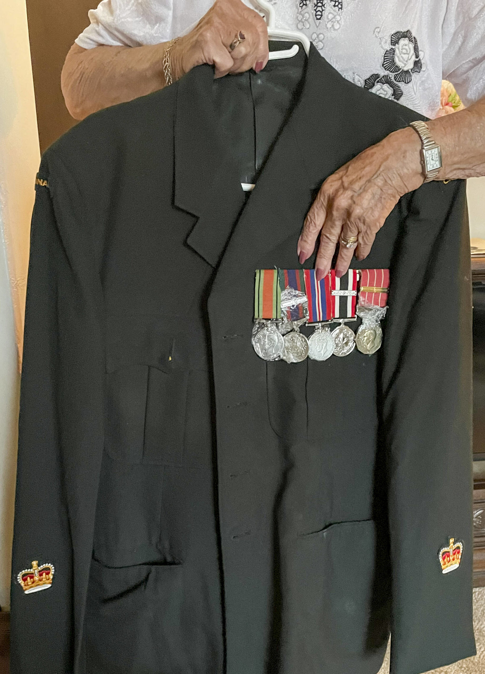 Thelma shows off Rays military uniform and medals. (Photo by Kelsey Yates)