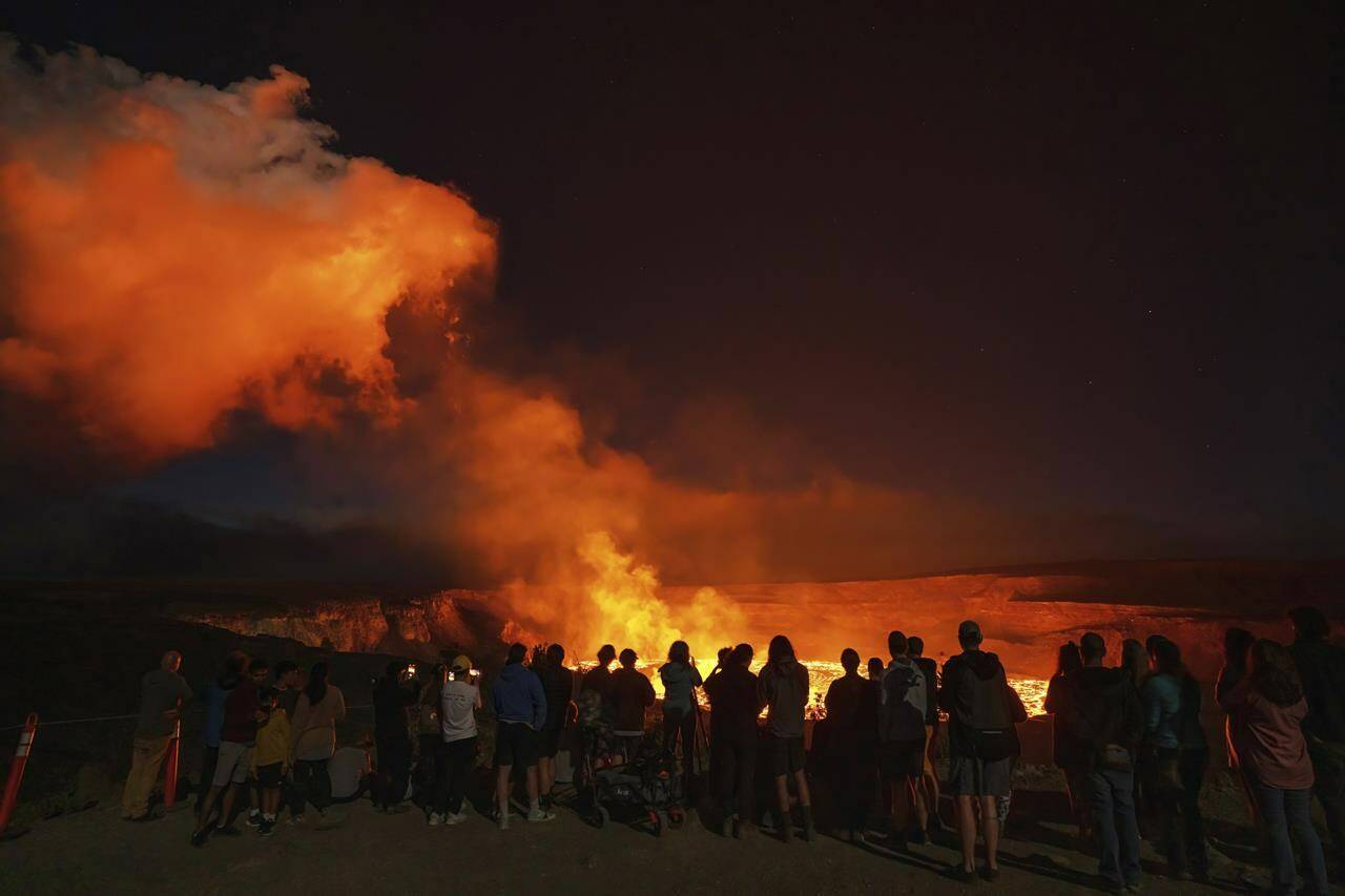 This photo provided by Janice Wei shows people watching the eruption inside the summit crater of the Kilauea volcano on the Big Island of Hawaii, Thursday, Jan. 5, 2023. Kilauea, one of the worlds most active volcanoes, is erupting again and providing a spectacle that includes bursting lava fountains and lava waves but no Big Island communities are in danger. (Janice Wei via AP)