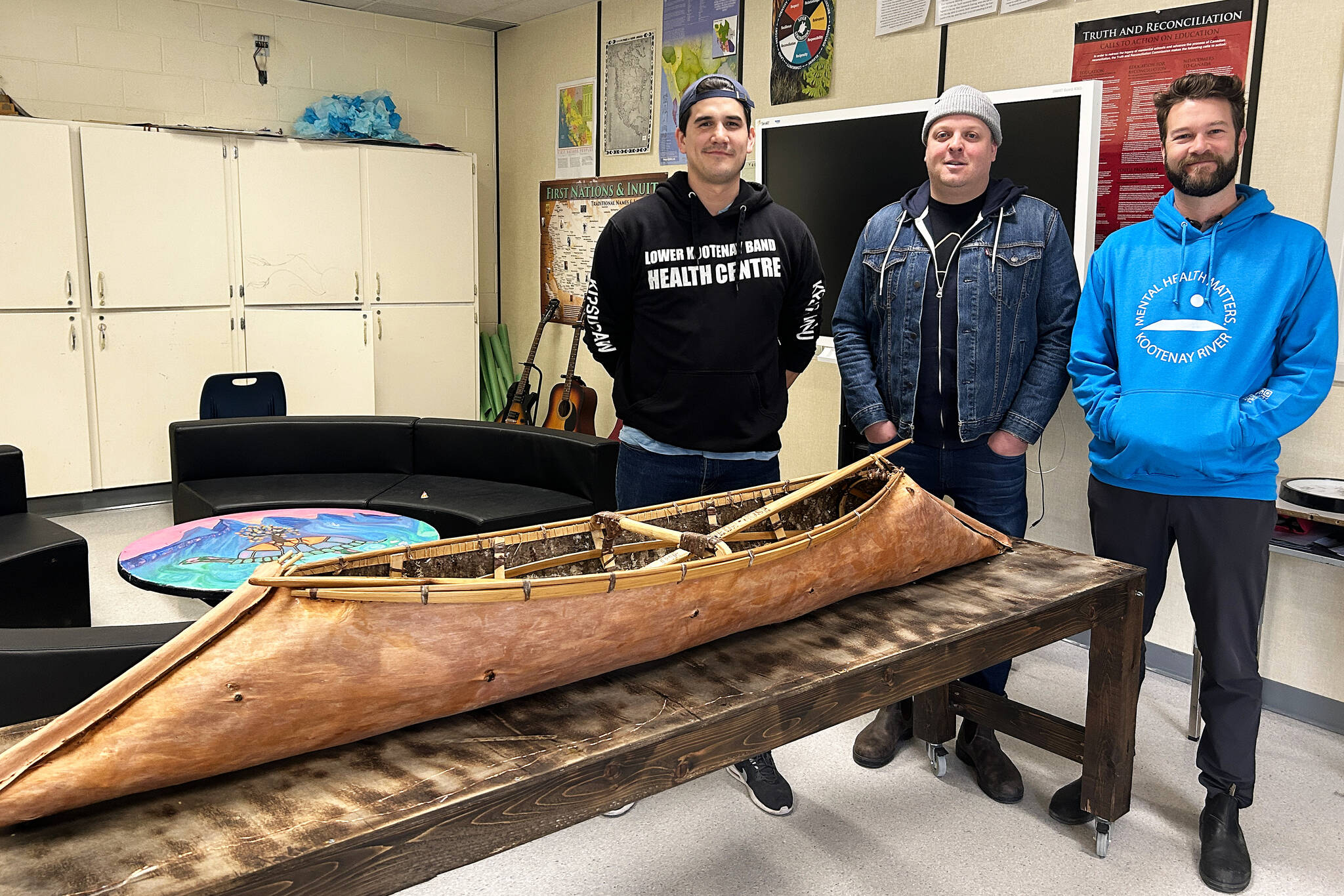 Teacher Ki Louie, school counsellor Michael Fischer, and KRSS principal Brian Hamm pose with a sturgeon-nosed canoe. (Photo by Kelsey Yates)