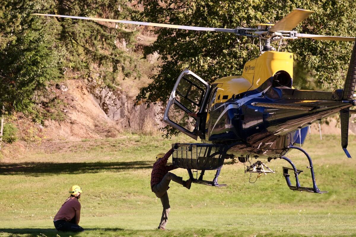 An SAR volunteer practises climbing in and out of a hovering helicopter. This is a necessary skill because there is often no flat landing site at a rescue scene. Photo: Bill Metcalfe