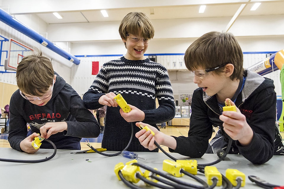 Parkview Elementary students Noah Handley and Dillon Whiting and Eagle River Secondary student Brandon Greenlaw work together at assembling the ned of electrical cords. Lachlan Labere/Eagle Valley News