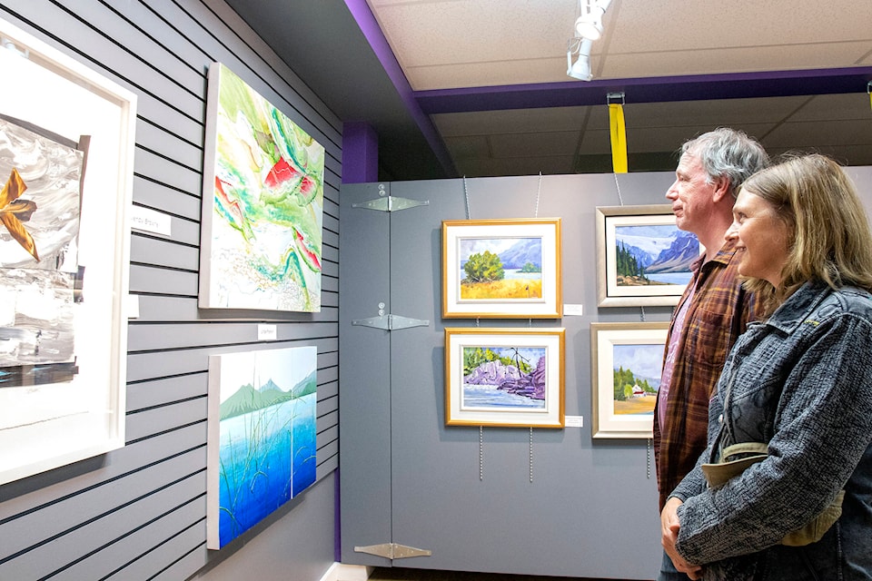 Doug Foster and Eberle Balfour peruse Linda Franklin and Wendy Browne’s work at the Lazuline Art Gallery Sept. 14 during the opening of the latest exhibit from the Shuswap Women’s Art Collective, a collection of nine female artists from the Shuswap. (Jodi Brak/Salmon Arm Observer)