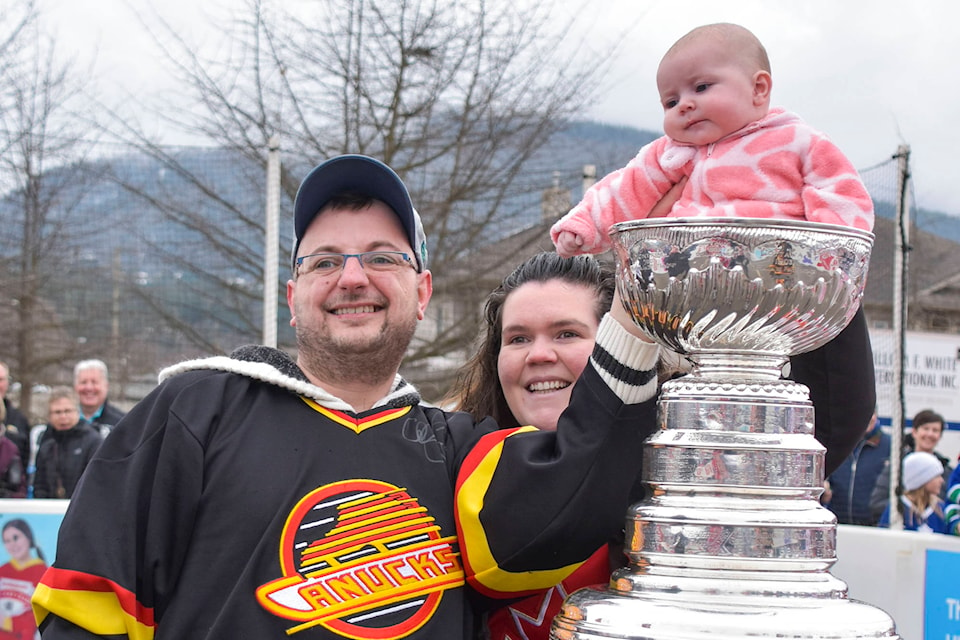 Scott and Toni Campbell stand next to their daughter Sydney Rose Margaret Campbell taking a seat in the Stanley Cup at the Rogers Hometown Hockey showcase in Salmon Arm on Saturday, March 7, 2020. (Cameron Thomson - Salmon Arm Observer)