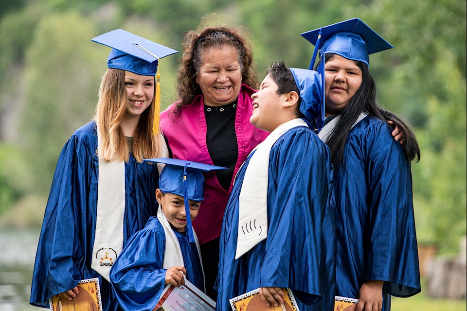 Celebrating success on June 20, 2020 are, from left in blue gowns, three Grade 5 grads and one Kindergarten grad, Tiana August Mattey, Hunter Mattey, Savanah August and Justice August from the Neskonlith band. Behind, proud grandma Yvonne August. (Photo courtesy of Kristal Burgess Photography)
