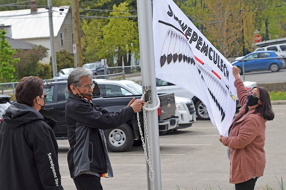 Neskonlith band councillor Cora Anthony looks on as Neskonlith councillor and knowledge keeper Louis Thomas raises the Secwepemculecw flag with help from Adams Lake councillor Gina Johnny on Friday, April 30, 2021 at the School District 83 District Education Support Centre in Salmon Arm. (Martha Wickett-Salmon Arm Observer)