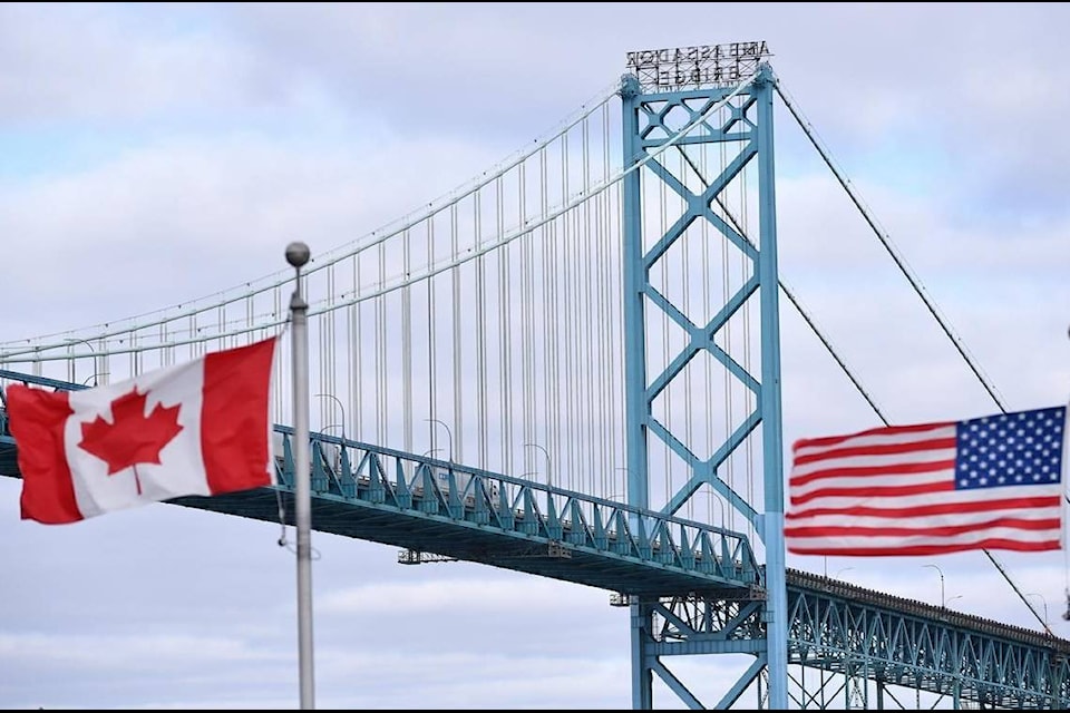 Canadian and American flags fly near the Ambassador Bridge at the Canada-USA border crossing in Windsor, Ont. on Saturday, March 21, 2020. Canadian residents are allowed to head to the United States for a COVID-19 vaccine and avoid quarantine on return if they meet some straightforward conditions, the Public Health Agency of Canada confirms.THE CANADIAN PRESS/Rob Gurdebeke