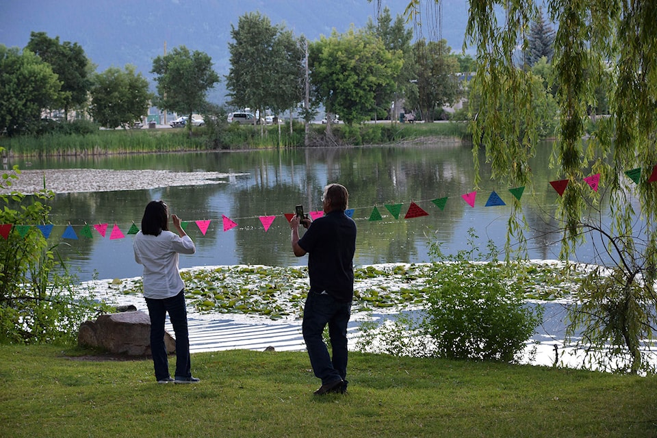 Following a walk around McGuire Lake in Salmon Arm to read poems posted for a vigil on Friday, June 25 to honour the victims of the targeted killing of a Muslim family in London, Ont., participants were welcome to write a thought on a small flag and display it with others. (Martha Wickett - Salmon Arm Observer)
