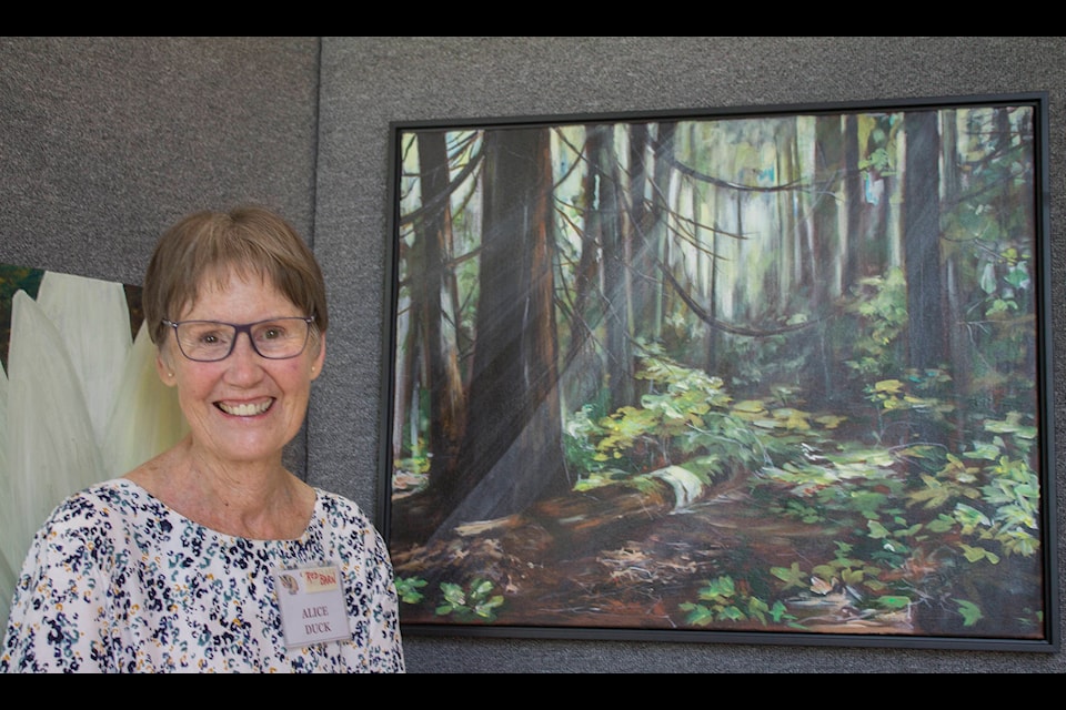 Eagle Valley Brush & Palette member Alice Duck shows off her painting at the 42nd Annual Art Show & Sale at the Red Barn Arts Centre in Sicamous on July 2, 2021. (Zachary Roman - Eagle Valley News)