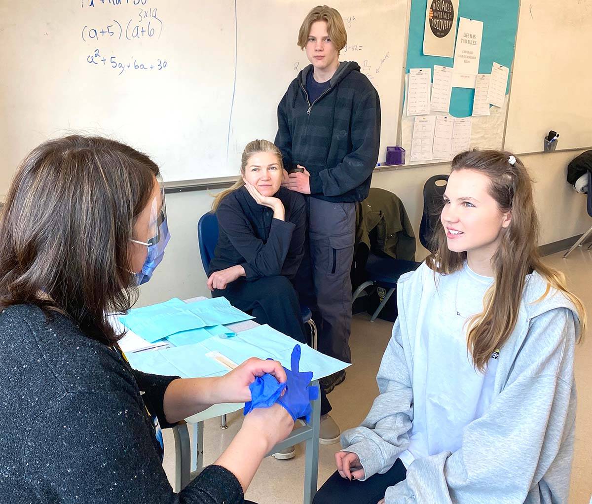 Dental hygene assistant Maruie Giella, left, of Interior Health prepares to examine Vlada Varnytska teeth. Watch in the background are her mother Vitalina and brother Ustym. There was a special oral health clinic for Ukrianian youth and their families. (Penticton Herald/LJI)