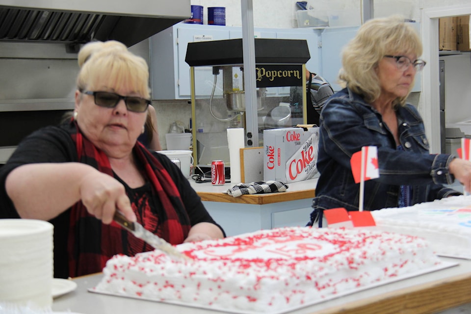 CUT THE CAKE - Mayor Helen Posti cuts one of two Canada Day cakes at the arena after the Reaffirmation of Citizenship. Photos by Megan Roth/Eckville Echo