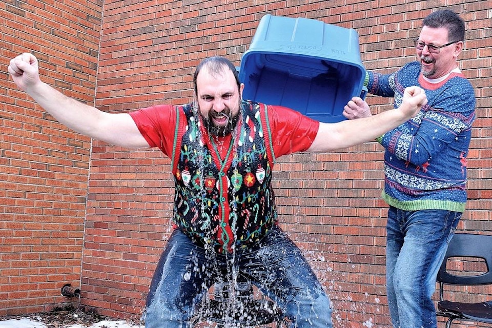 Mr. Magneson takes an ice bucket plunge on Dec. 20. Grade 11 student Heather Dial and Eckville Junior/Senior High School Principal Brian Holland (right) had the opportunity to dump the bucket of ice water on Mr. Magneson outside on a chilly December afternoon. The event served as a fundraiser bringing in $165 for Eckville FCSS and the Red Deer Women’s Shelter. Photo by Kaylyn Whibbs/Eckville Echo