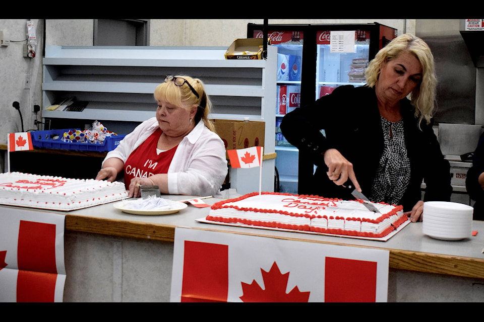 Mayor Helen Posti (left) and Lacombe County Councillor Dana Kreil cut into two of the three cakes for Canada’s 152nd birthday. People packed the Eckville Arena on July 1 to celebrate Canada Day with hot dogs, cake and fun activities. Photo by Kaylyn Whibbs/Eckville Echo
