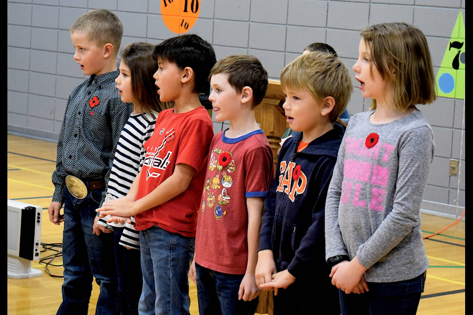 Members of Eckville Elementary School’s Grade 2 class recite the poem “In Flanders Fields” at the school’s Remembrance Day service on Nov. 7. Photo by Kaylyn Whibbs/Eckville Echo