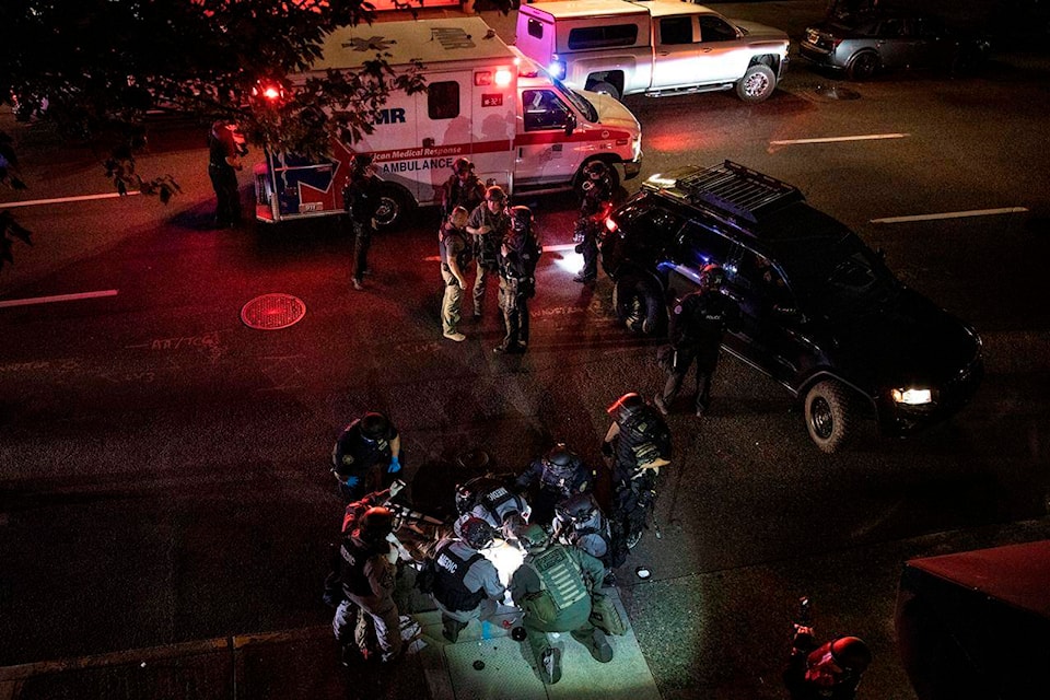 A man is treated by medics after being shot during a confrontation on Saturday, Aug. 29, 2020, in Portland, Ore. Fights broke out in downtown Portland as a large caravan of supporters of President Donald Trump drove through the city, clashing with counter-protesters. (AP Photo/Paula Bronstein)