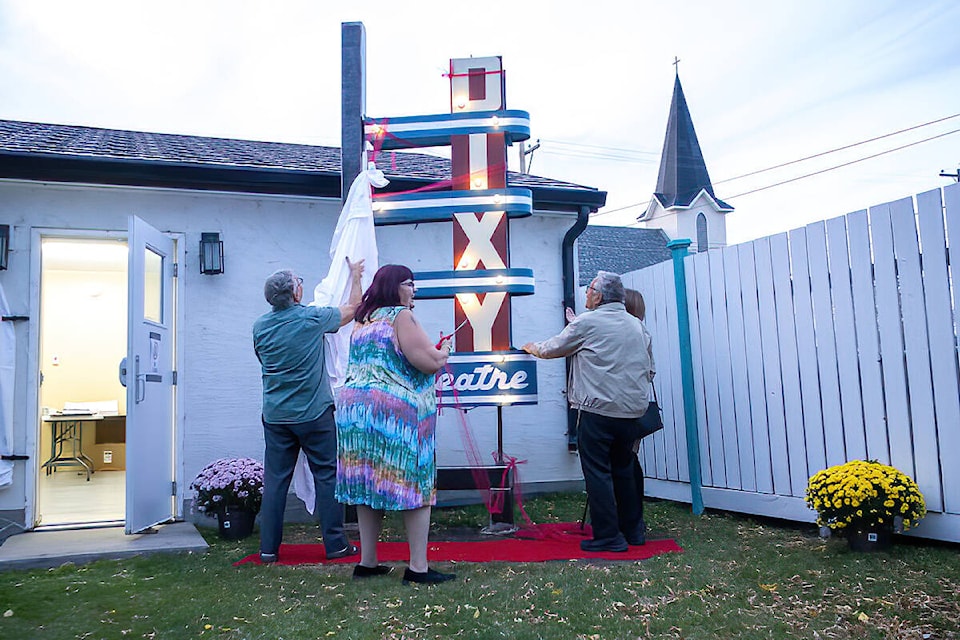 Shelley Boileau and the Dick family uncover the Dixy Theatre sign. (Kevin Sabo/Bashaw Star)