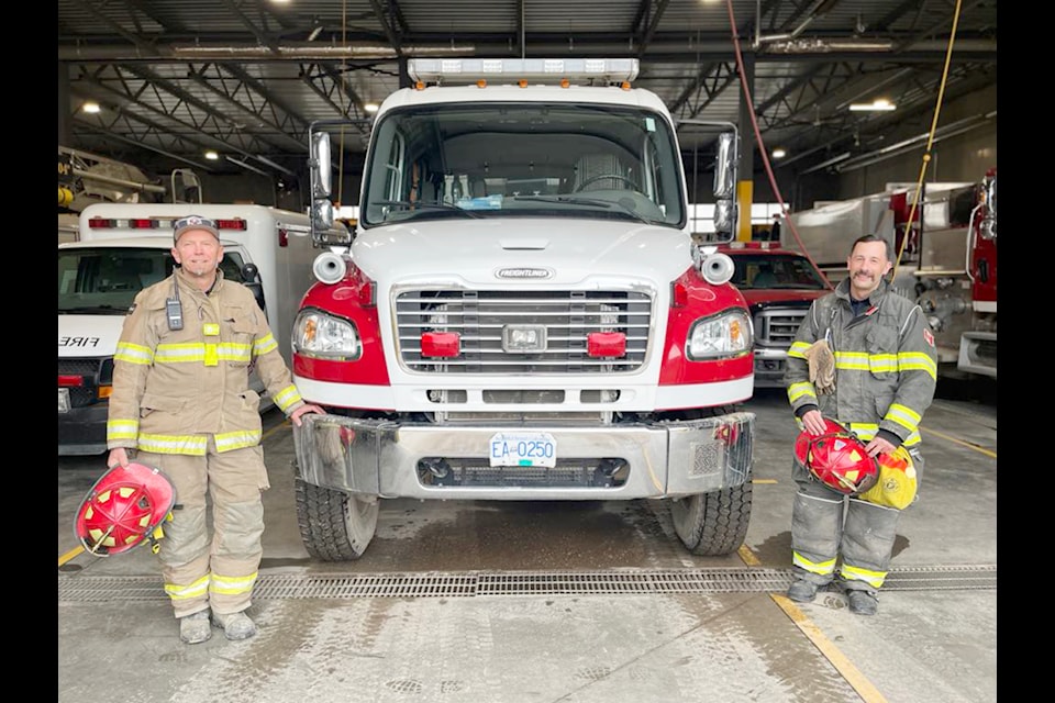(L-R) Firefighters Troy MacLachlan and Sean Gigliotti stand with a fire truck during the fire hall open house on Apr. 10 (Gillian Francis/TheFreePress)