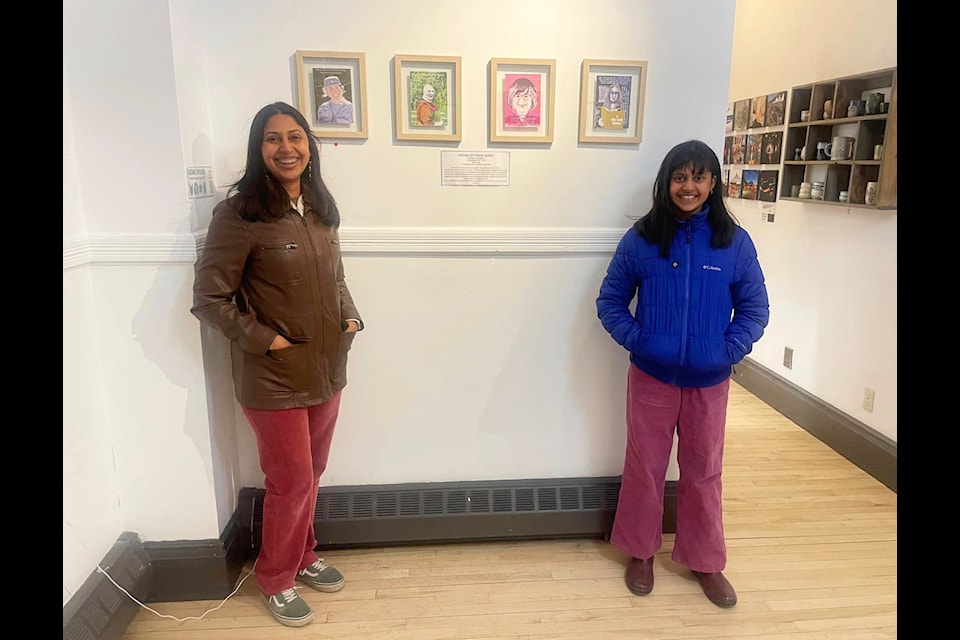 Pruthvi Harshan and her daughter Anya stand with Harshan's portrait series at The Art Station. The exhibit features work from more than a dozen artists in celebration of International Women's Day (Courtesy of Pruthvi Harshan)