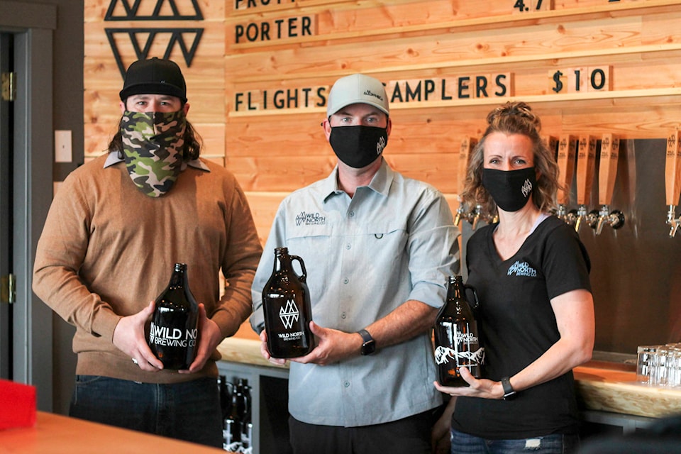 Brewmaster Casey Staple and co-owners Craig and Lisa Wood pose at Wild North Brewing Company on their opening day. (Photo by Kelsey Yates)