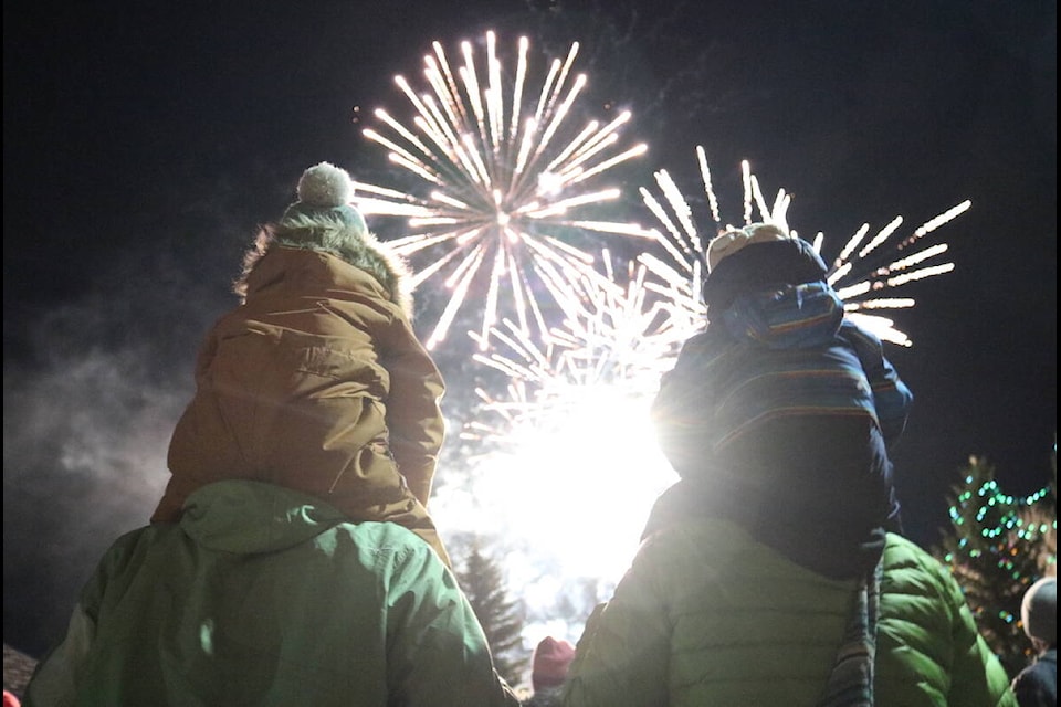 Noah Houde sits on the shoulders of Mikael Houde (left) next to Manu Houde sitting on the shoulders of Mira Achard (right). The family was enjoying the firework display at the Light Up The Night event in Fernie on Nov. 26, 2021.