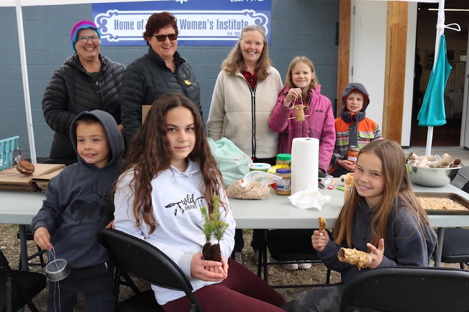 Kids at the Earth Day-themed market in Grasmere on Apr. 23, 2022, had the chance to make bird feeders, planters, wind chimes, and got to bring home little pine trees to plant. Front row, left to right: Austin Ryder, Heidi Matejka, Mackenzie Ryder. Back row left to right: Karen Barton, Susan Hoszouski, Cathy Betteridge, Taylor Betteridge, Chase Betteridge. (Joshua Fischlin/The Free Press)