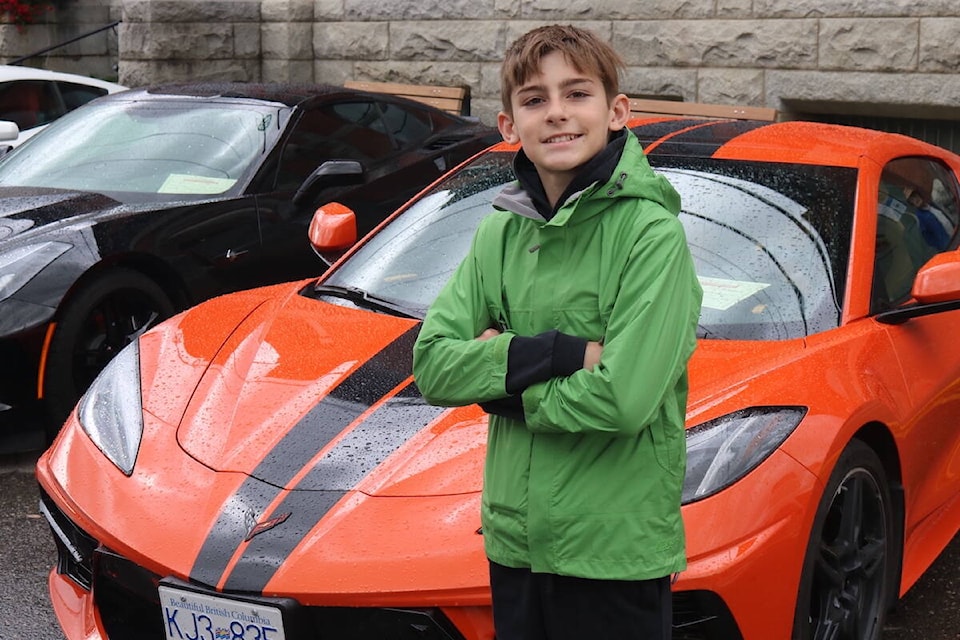 Peter Sczesny, 12, in front of an orange Corvette that was on display at the 10th annual Show N’ Shine in Fernie, held on Saturday, Aug. 27, 2022. He said he would want the car to be his first. (Joshua Fischlin/The Free Press)