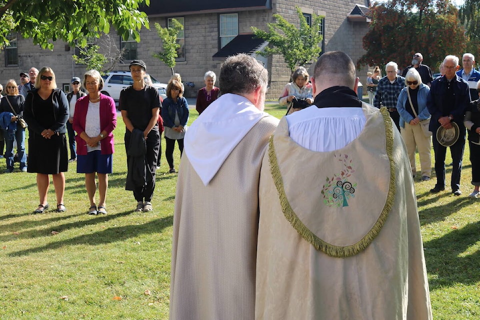 Father David John and Reverend Canon Andrea Brennan together in front of gathered community members in Fernie at an event to commemorate Queen Elizabeth II on Sept. 19, 2022. (Joshua Fischlin/The Free Press)