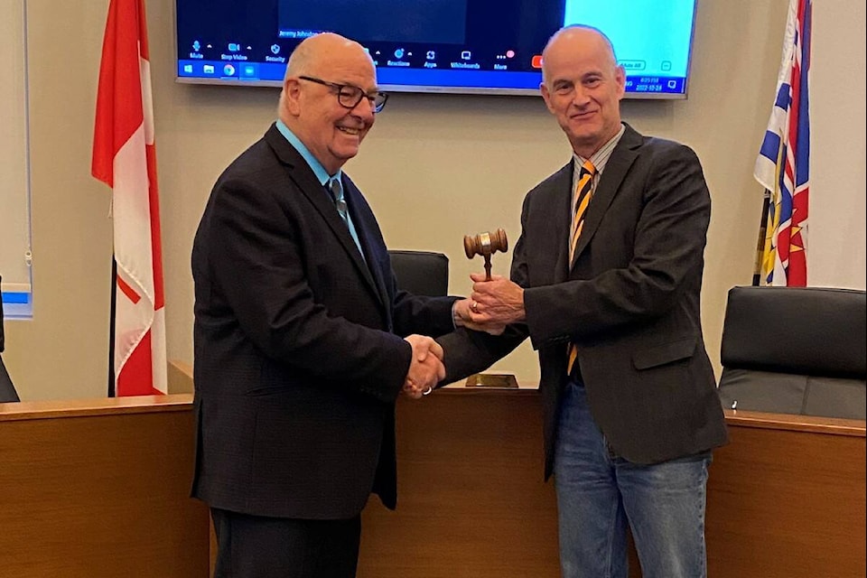 Elkford’s outgoing, long-time mayor, Dean McKerracher, handing over the town’s original gavel to mayor-elect Steve Fairbairn, at a District of Elkford council meeting on Oct. 24, 2022. It was the final meeting of the outgoing council before the new one is inaugurated on Nov. 7, 2022. (Courtesy of District of Elkford)