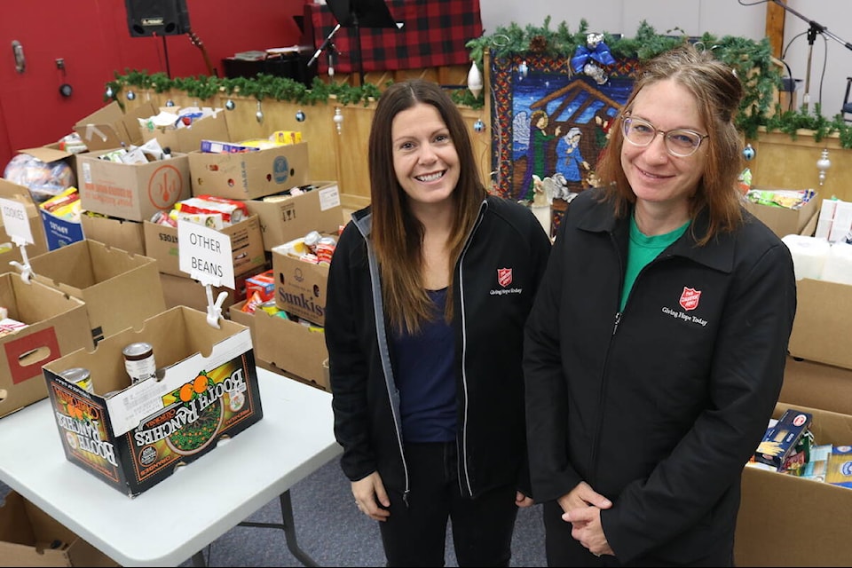 Sarah Hannath (left) and Jennifer Robins of the Fernie Salvation Army, standing amidst 4,700 pounds of donations collected for the food bank during the annual Emergency Medical Services Food Drive that took place on Wednesday, Nov. 16, 2022. (Joshua Fischlin/The Free Press)