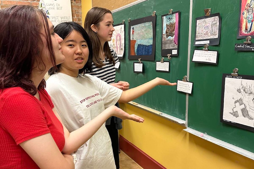 Himari Fukada discussing her artwork with classmates Lorraiya Blurton and Kayla Scott at a presentation of work done by the Grade 10 art class at the Fernie Academy on the subject of ‘Make Art Not War’ on Wednesday, Nov. 23, 2022. (Submitted by Karen Luzny)