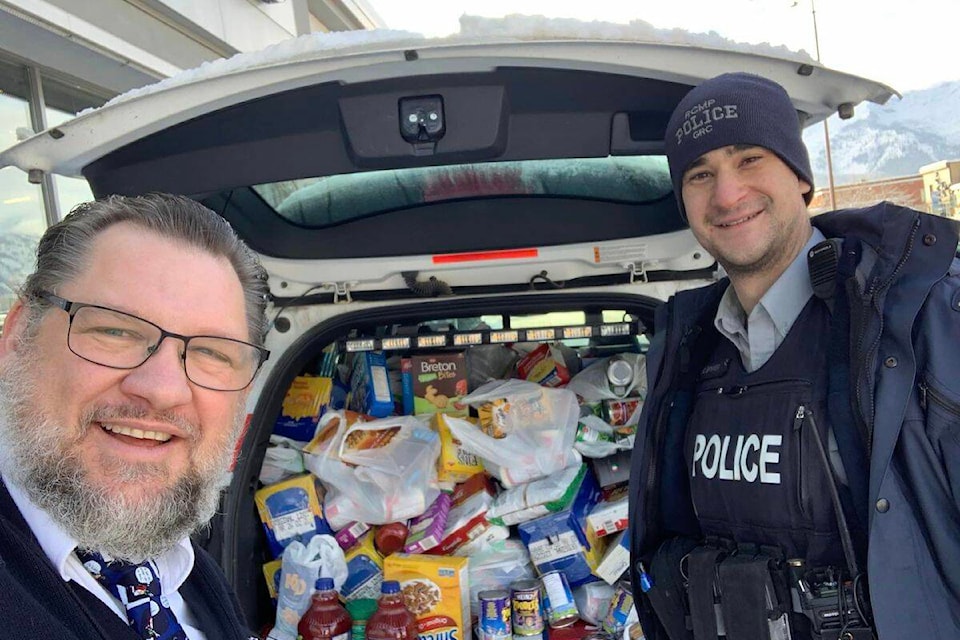 Major Rick Robins of the Fernie Salvation Army and Const. Chris Spyker of the Elk Valley RCMP in front of a haul for the food bank collected in front of Save-On-Foods during ‘Operation Pack a PC’ on Sunday, Dec. 11, 2022. (Courtesy of the Fernie Salvation Army)