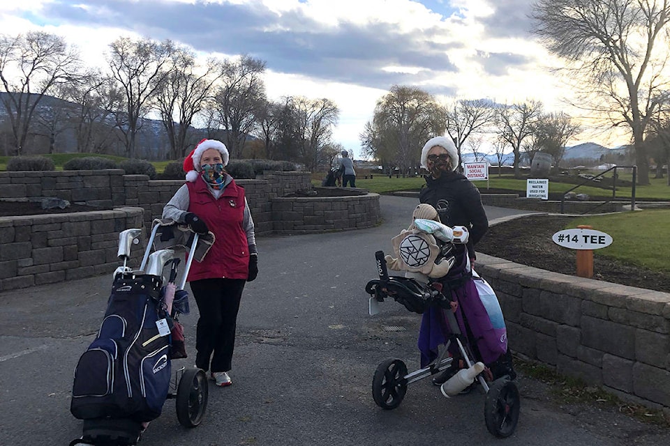 Donning Santa hats, Ellsy Mackie and her friend head off for their last golf game of the season on Dec. 20, 2020. (Monique Tamminga / Western News)