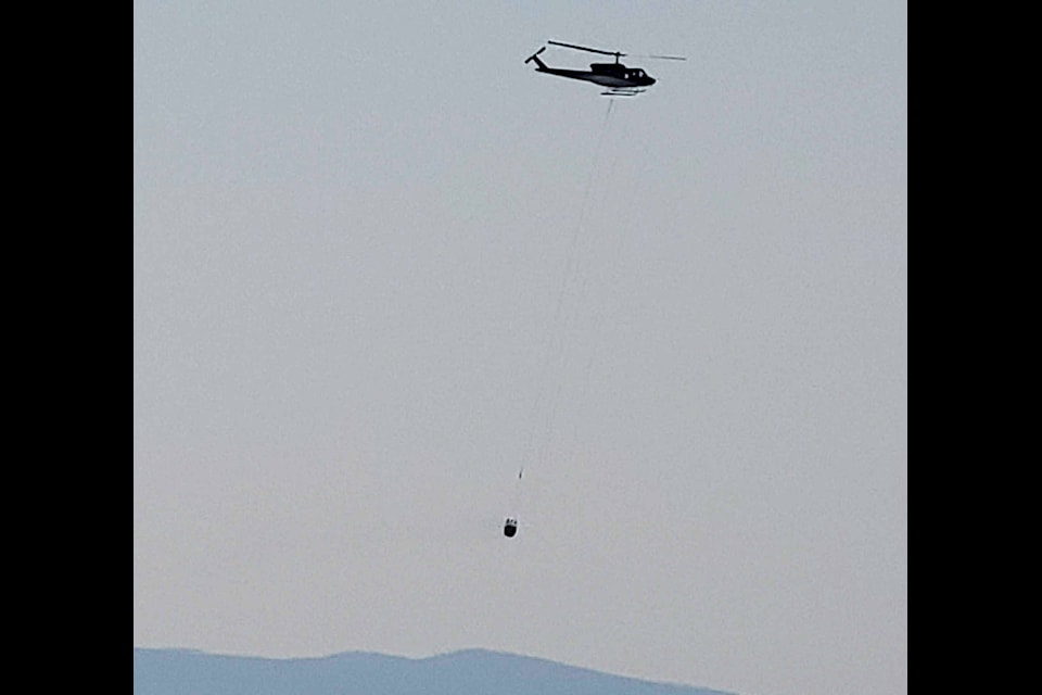 A helicopter is actioning a fire in the hills above BX-Swan Lake Monday afternoon. (Roger Knox - Morning Star)