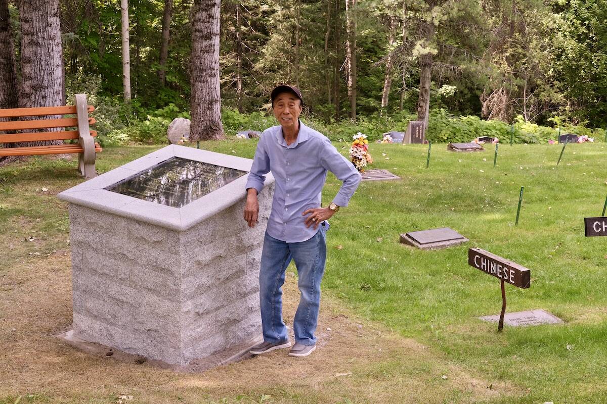 Tim Jay at the new memorial plaque, with the sign that indicates the Chinese section of the Nelson cemetery. Photo: Bill Metcalfe