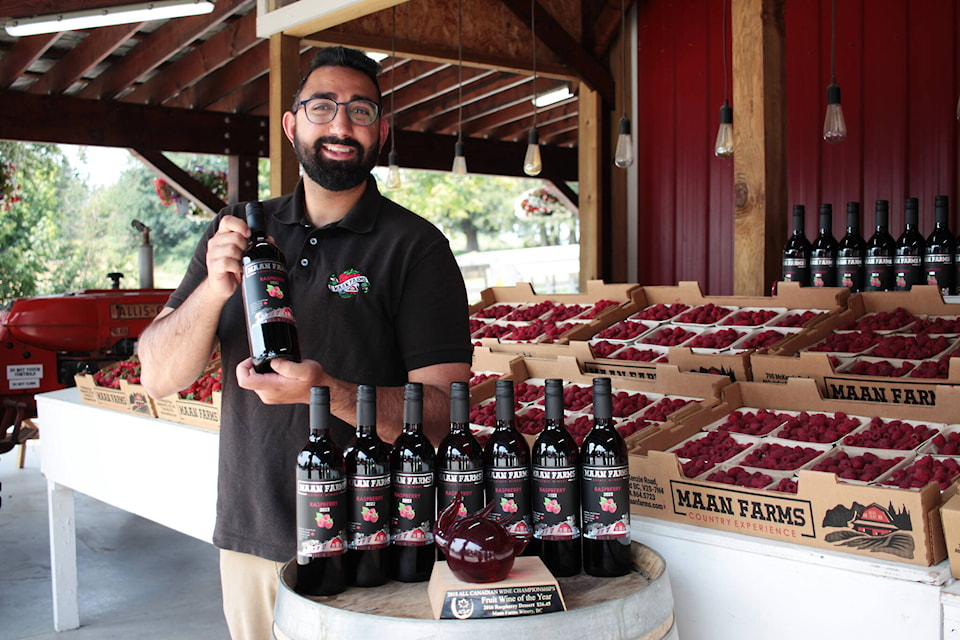 Maan Farms winery manager Gaurav Maan holds a bottle of the 2022 raspberry fruit wine, which recently won an award. (Lauren Collins)